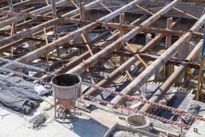 post-and-beam system with metal beams and concrete pillars at a construction site