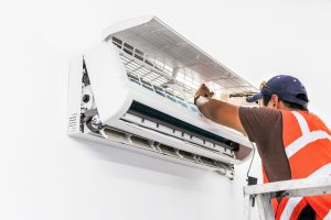 Young repairman fixing a ductless minisplit air conditioning system